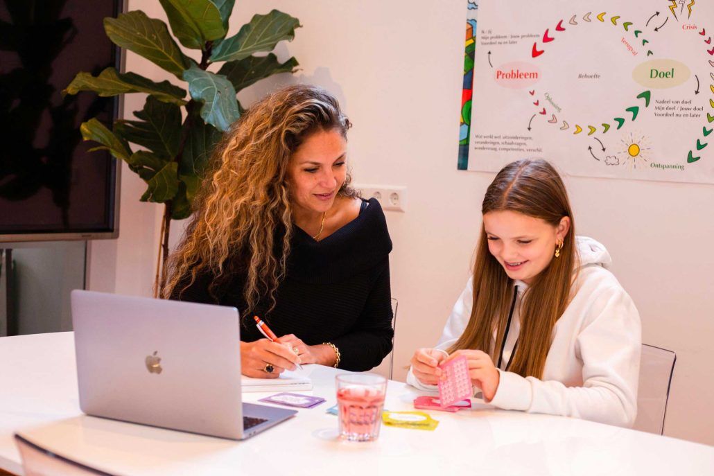 Examentrainer begeleidt een kleine groep examenkandidaten bij mooi jong